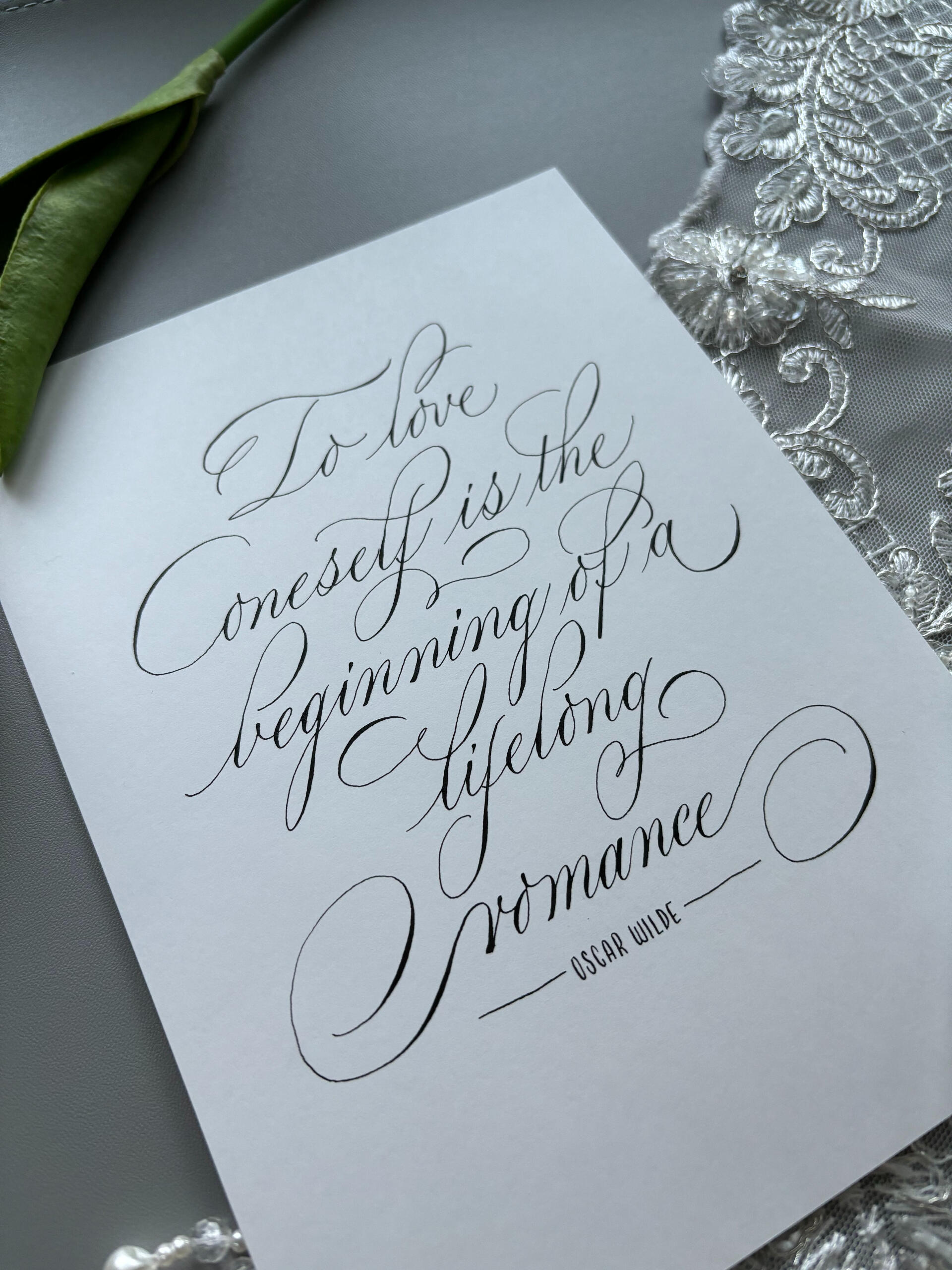 ชิ้นงาน "To love oneself is the beginning of a lifelong romance." คำกล่าวโดย Oscar Wilde ศิลปินนำมาออกแบบตัวอักษรในรูปแบบ Calligraphy โดยใช้ Pointed pen หรือ Dip pen (ปากกาจุ่มหมึก) วาดตัวอักษรออกมาบนกระดาษ